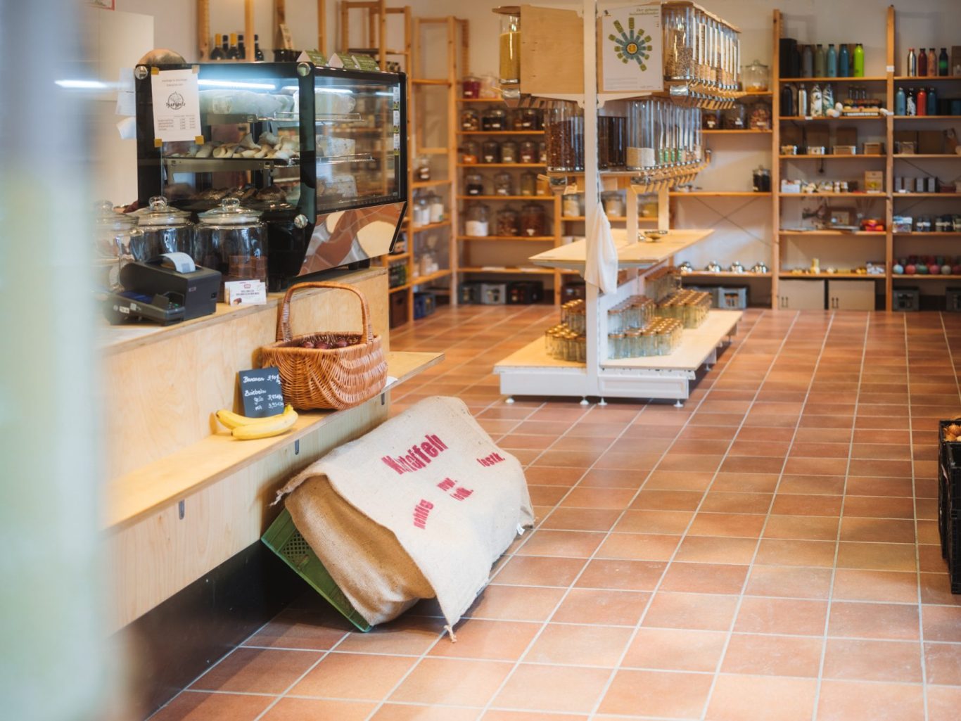 Laden von innen mit Sicht auf die Kasse mit Käsefrischetheke, Schüttspender und Bonbonieren.