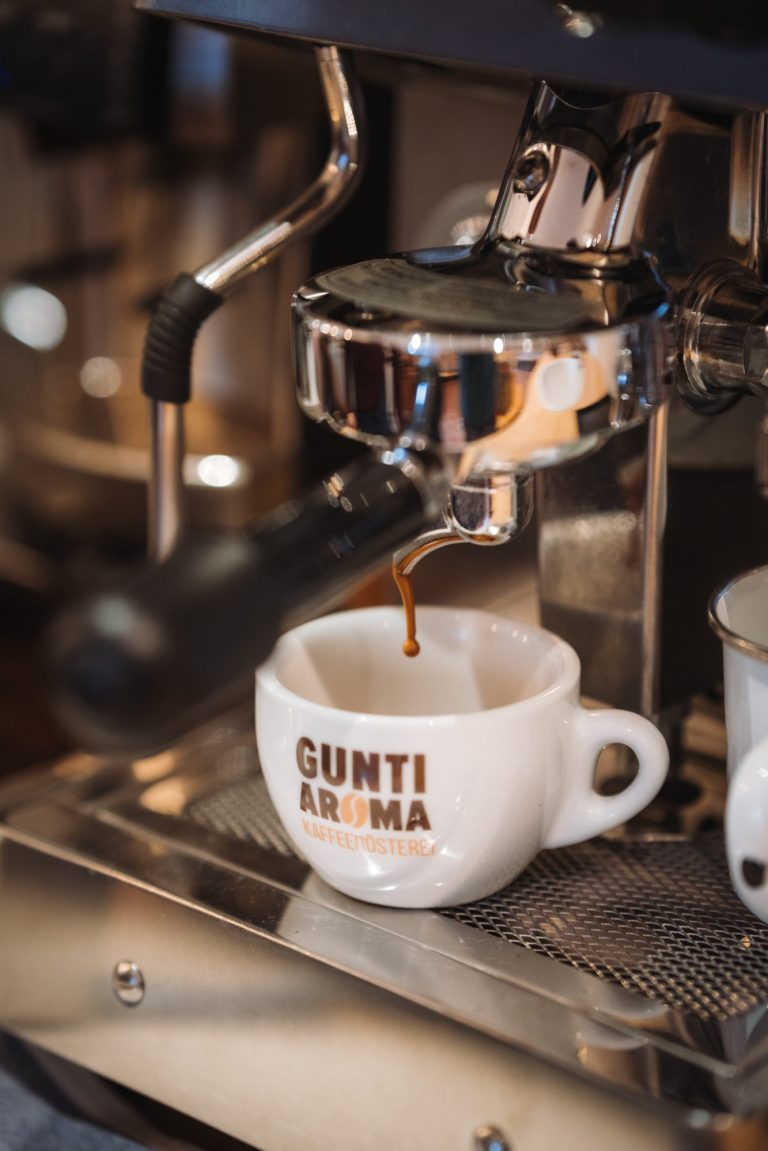 Siebträgermaschine mit Tasse. Espresso beginnt in die Tasse zu fließen.